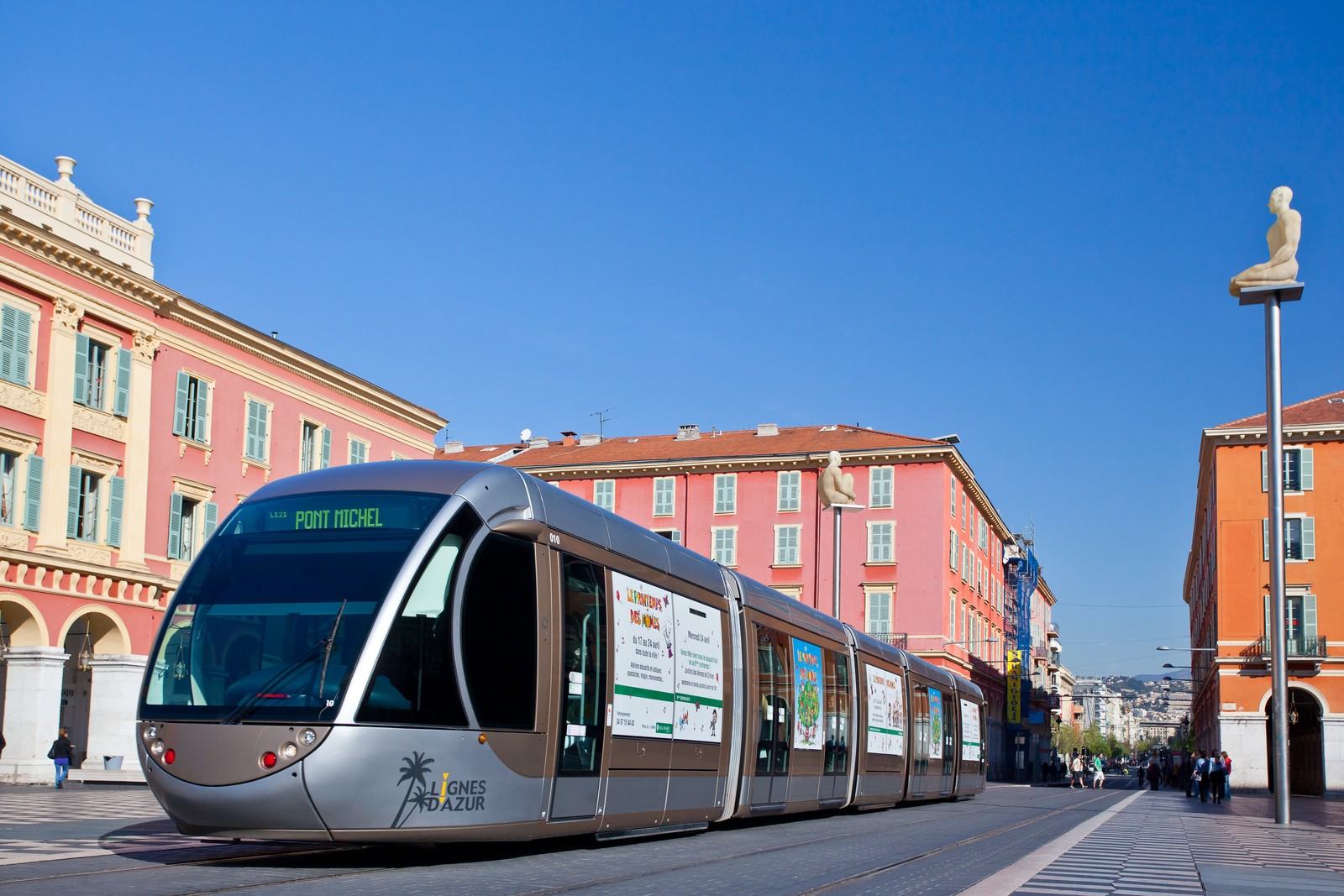 Le tramway devant les façades rouges de la place Masséna à Nice
